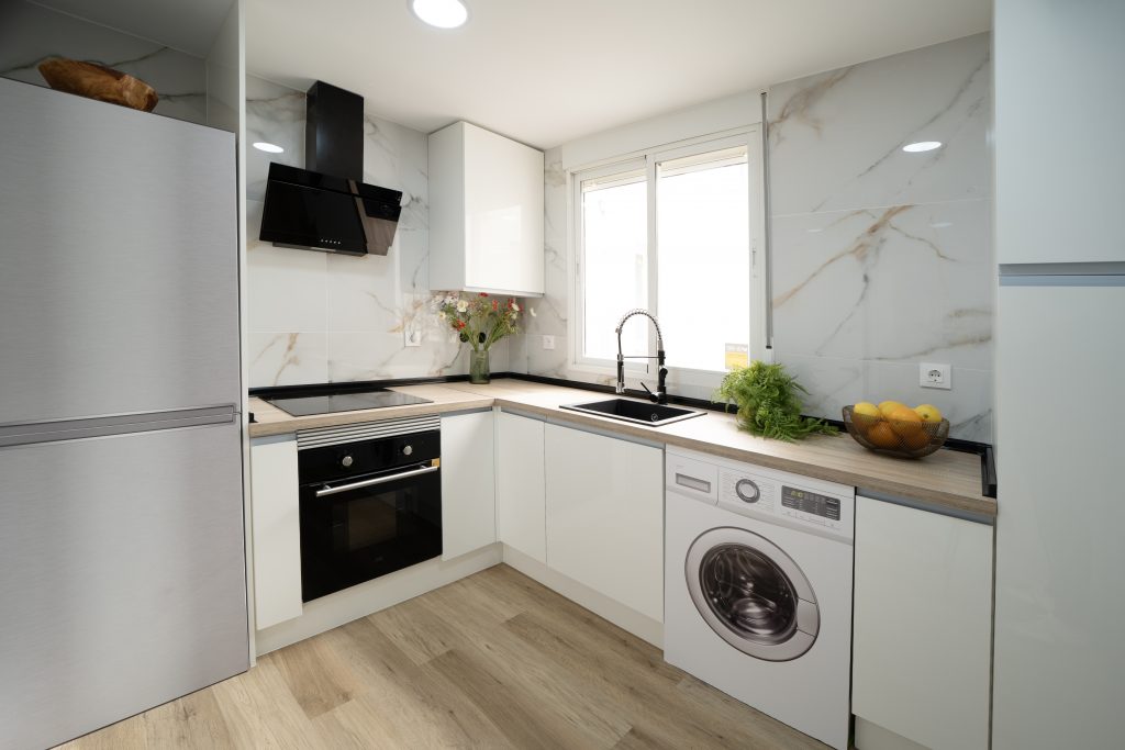 Cocina de diseño reformada con encimera de madera, fotografía inmobiliaria profesional en Valencia.