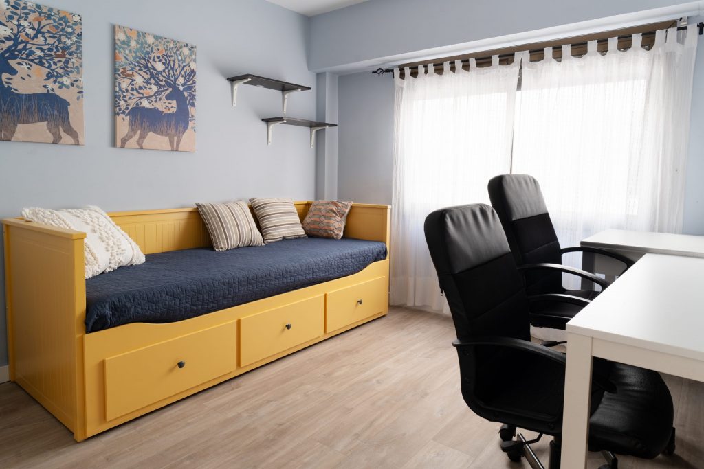Habitación juvenil con escritorio y luz natural, fotografía de interiores en Valencia.