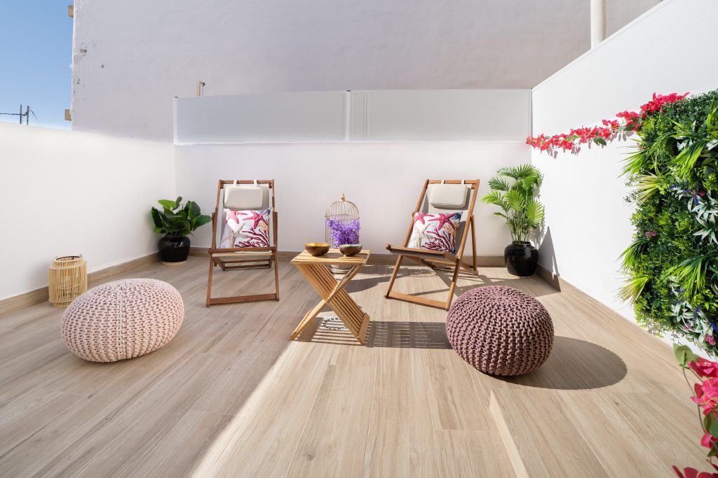 Terraza de ático con zona de relax y tumbonas en Valencia, fotografía inmobiliaria de exteriores.